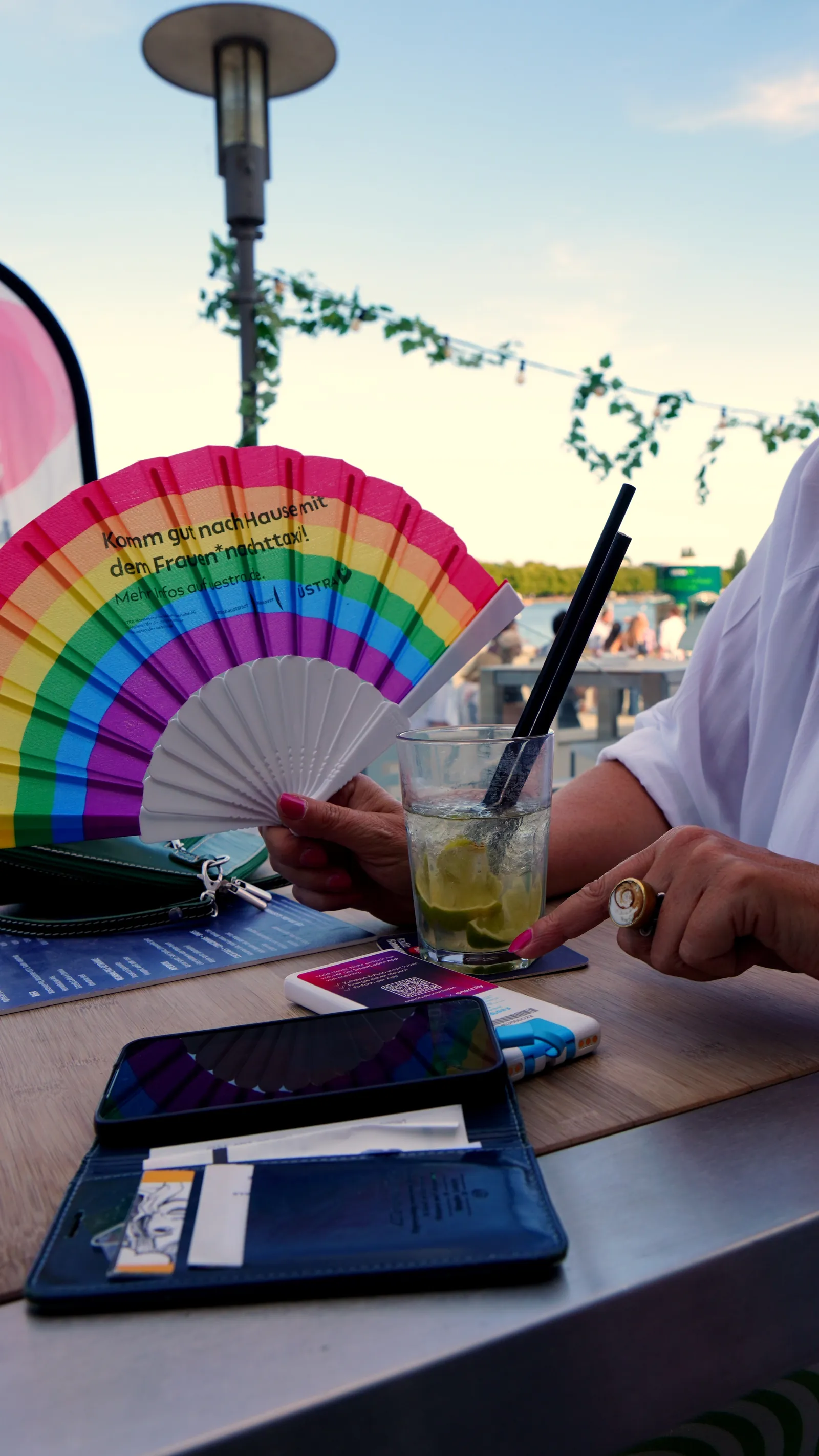SHARE Powerbank auf dem Biertisch, daneben lädt ein Handy